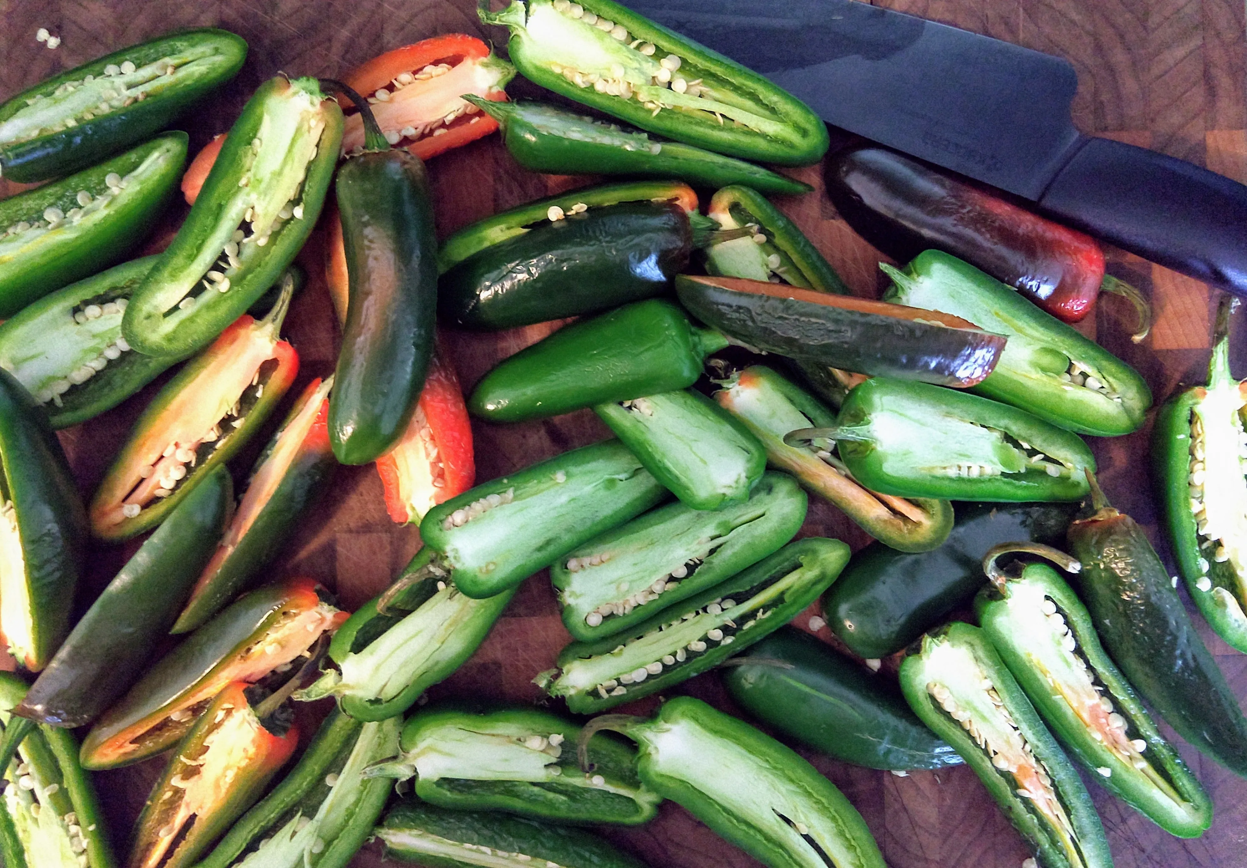 Jalapeno peppers sliced in half down the length of the pepper.